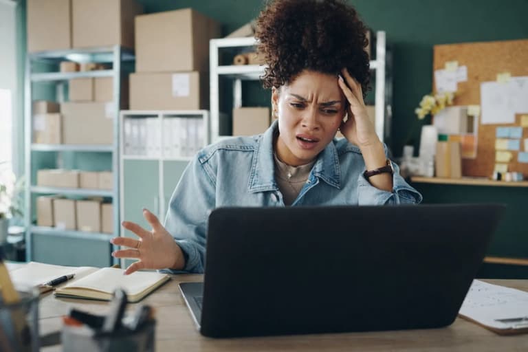 Small business owner at a desk, laptop open